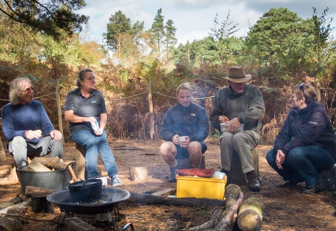 People enjoying sitting our an outdoors campfire