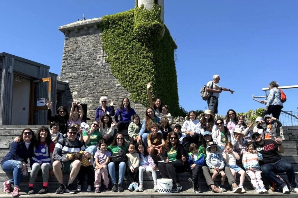 Group of school children at Durlston Country Park sitting on the steps outside the Castle.