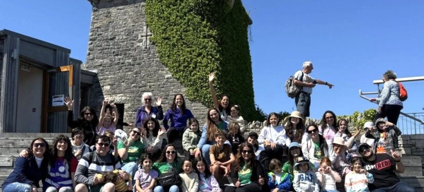 Group of school children at Durlston Country Park sitting on the steps outside the Castle.