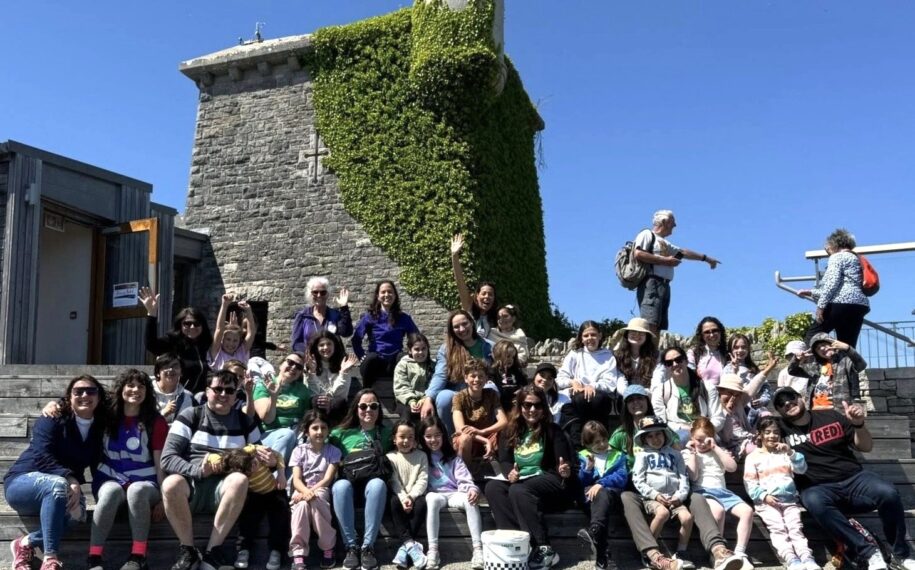 Group of school children at Durlston Country Park sitting on the steps outside the Castle.