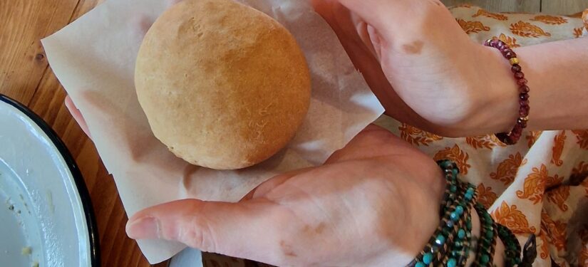 Two hands hold a freshly baked bread roll