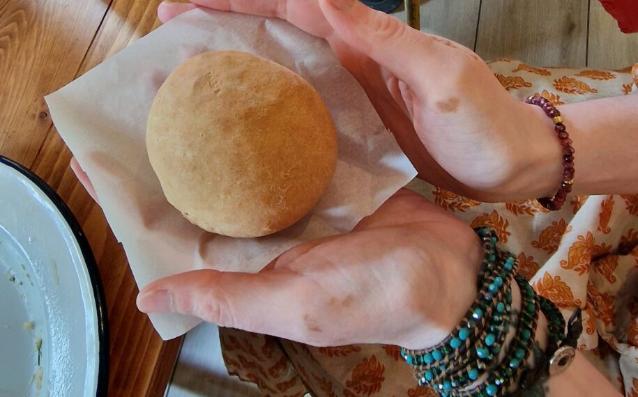 Two hands hold a freshly baked bread roll
