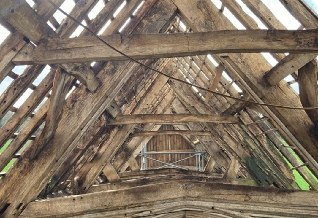 Old wooden beamed roof and arches supported by scaffolding