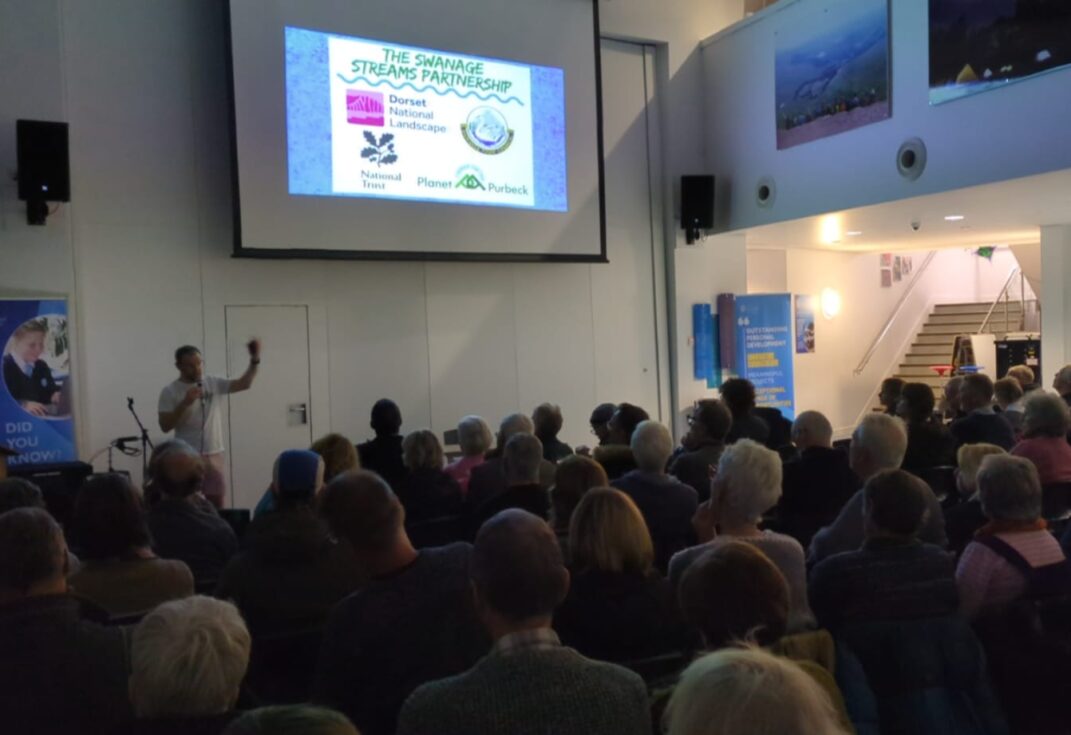 People looking at a presentation about the Swanage Streams Partnership.
