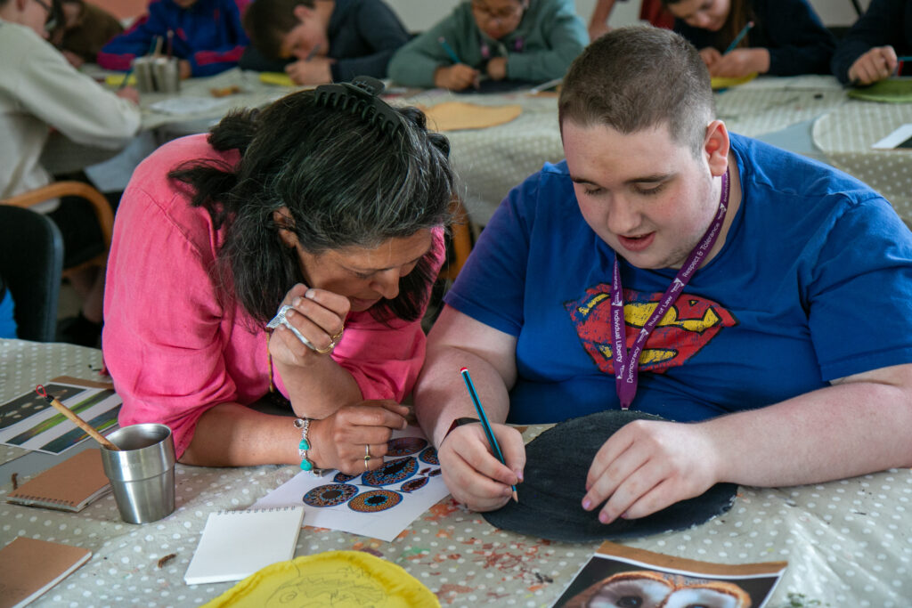 Two people at a table making artwork