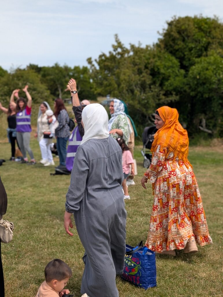Group of women and a child in a circle, taking part in an outdoor activity.